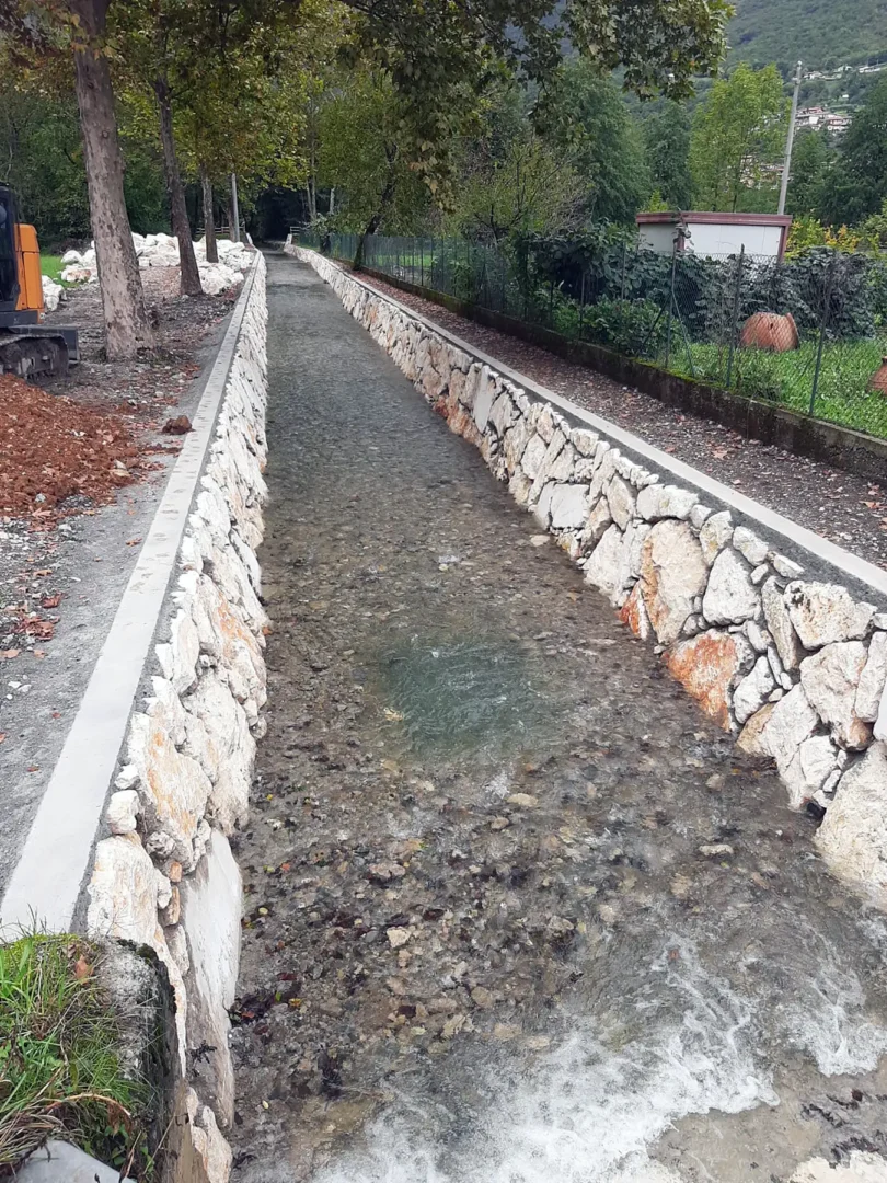 Canale con argini in pietra per opere fluviali e sistemazione idraulica del corso d’acqua