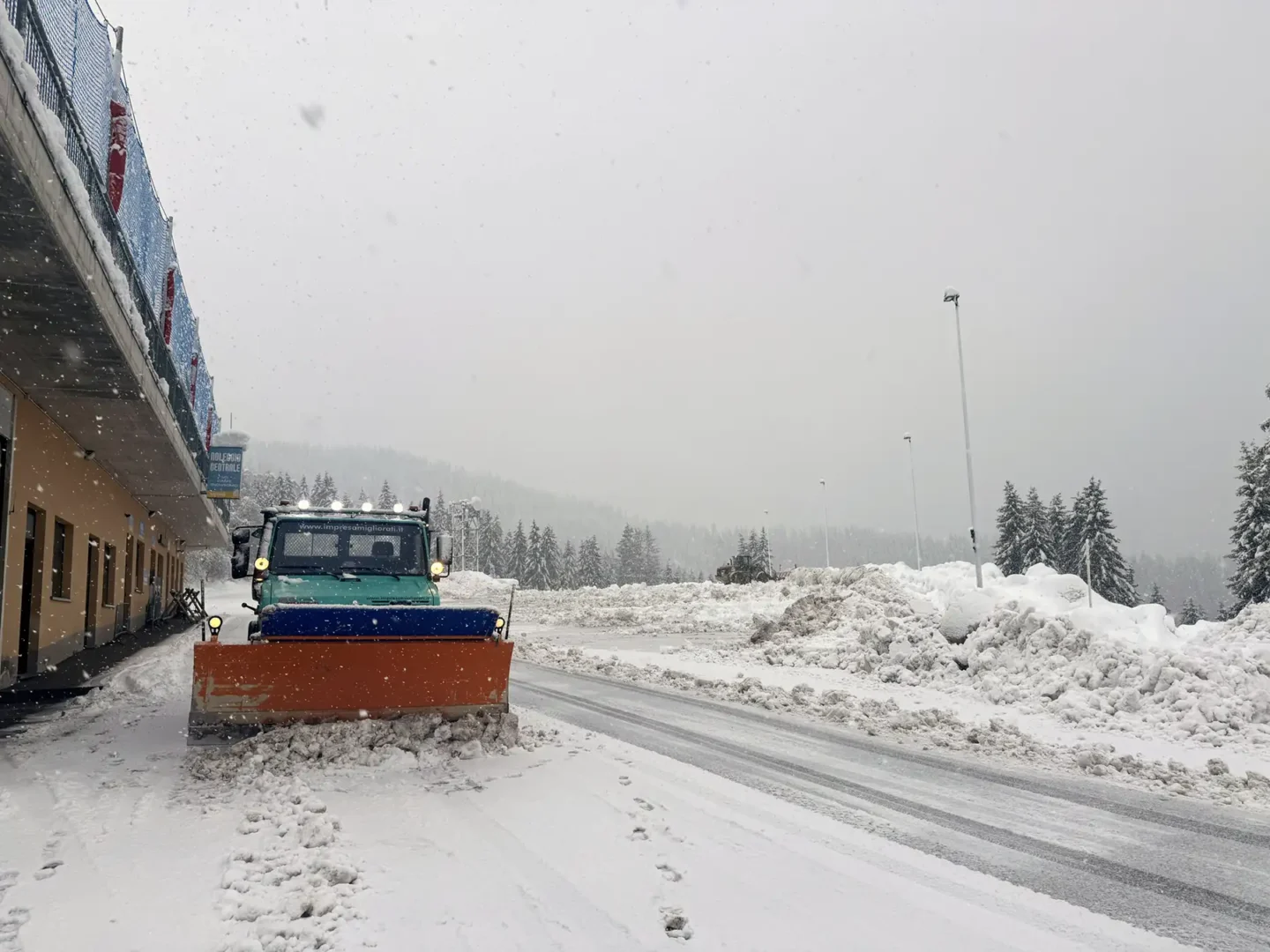 Sgombero neve con camion e lama spartineve per pulizia stradale in inverno