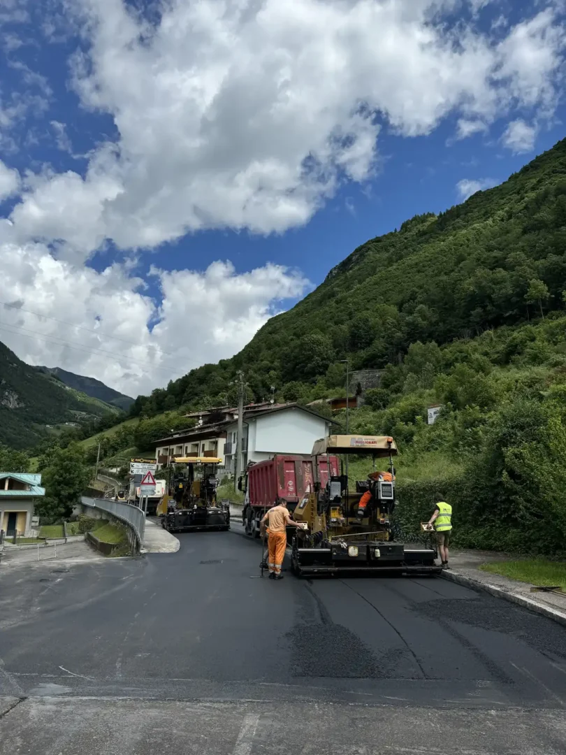 Lavori stradali con asfaltatura della carreggiata e mezzi operativi su strada